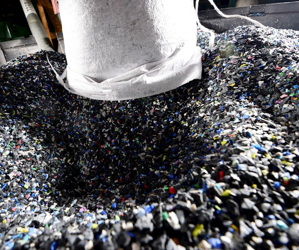 A pile of plastic is being poured into a machine.