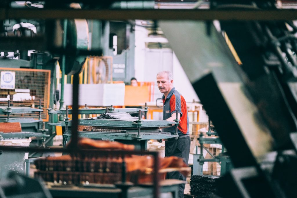 A man in a factory working on a machine.