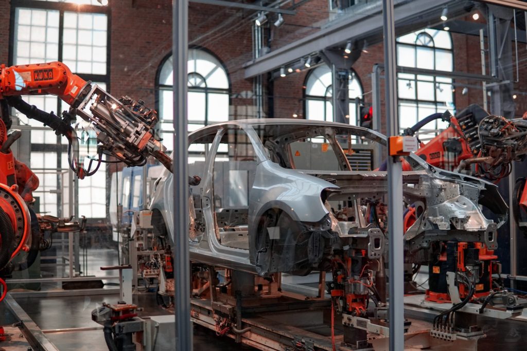 Robots working on a car in a factory.